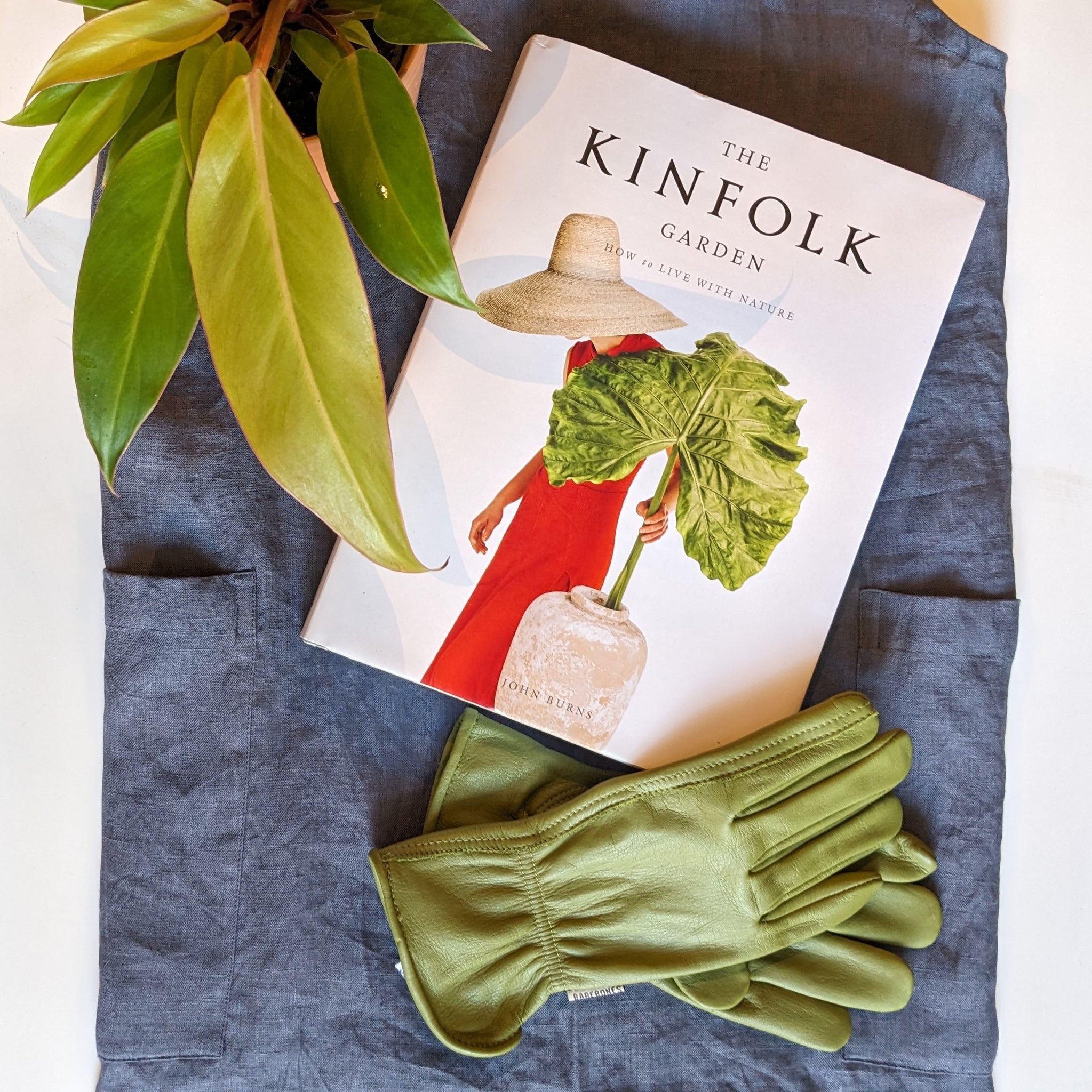 Kinfolk Garden Book; Green gardening gloves; Blue linen apron, Sun Red Philodendron